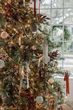 a decorated christmas tree in front of a window