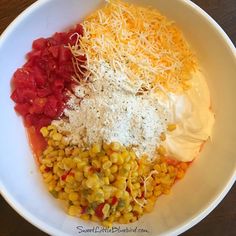 a white bowl filled with corn, cheese and other toppings on top of it