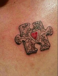 a cross tattoo with a heart in the middle on someone's back shoulder and chest