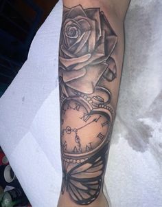 a black and white photo of a rose with a clock on it's arm