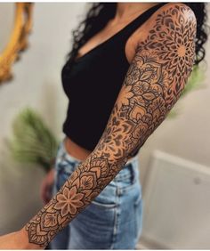 a woman's arm with an intricate tattoo design on her left arm and shoulder