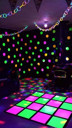 a room that has some lights on the wall and colorful tiles in it, all lit up