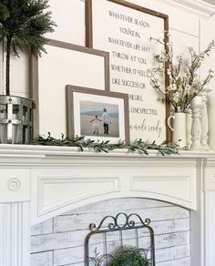 a mantel decorated with greenery and pictures on top of it, including a fireplace