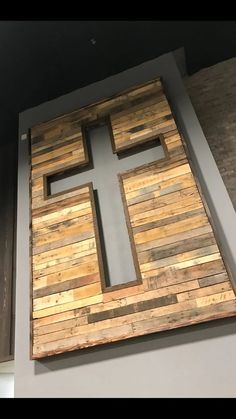 a cross made out of wood on the side of a building