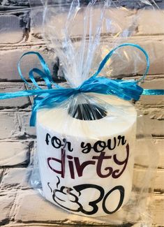 a roll of toilet paper wrapped in plastic and tied with a blue ribbon that says, for your dirty 30th birthday