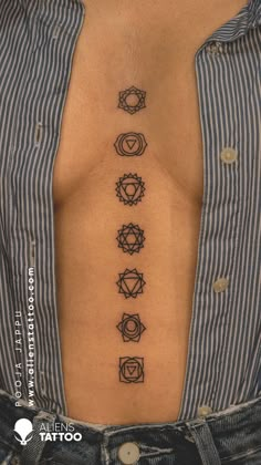 a woman's chest with seven chakras tattooed on the back and side