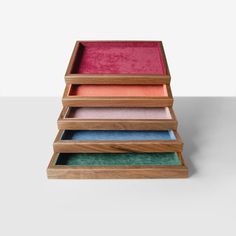 three wooden trays with different colored velvet lining on each side and one in the middle