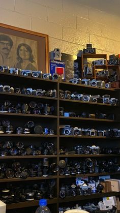 a room filled with lots of different types of cameras on shelves next to each other