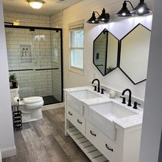 a white bathroom with two sinks and three mirrors on the wall next to each other