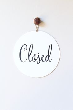 a close up of a sign on a wall with the word closed written in cursive writing