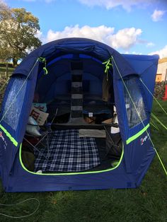 a blue tent sitting on top of a lush green field