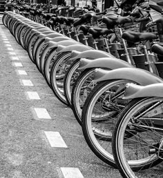 there are many bikes lined up on the side of the street in this black and white photo