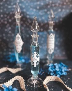 two glass bottles sitting on top of a table next to blue and white confetti