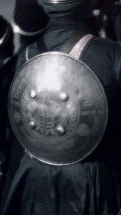 a man wearing a helmet and holding a metal plate with writing on the side,