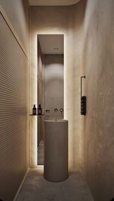 a narrow hallway with a sink and toilet in the center, surrounded by beige walls