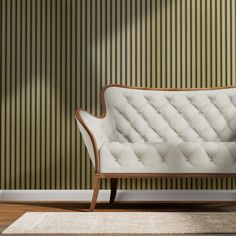 a white couch sitting on top of a hard wood floor next to a green wall