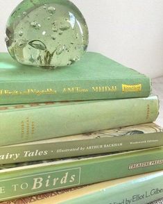 several books stacked on top of each other with a glass ball sitting on top of them