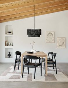 a dining room table with chairs and a rug on the floor