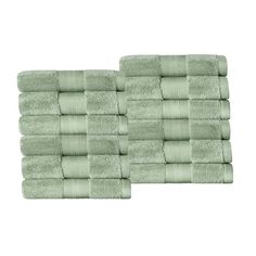 two sets of green towels stacked on top of each other in front of a white background