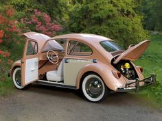 an old pink car is parked on the side of the road with its door open