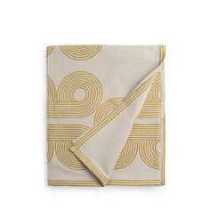 a white and gold napkin with circles on it, folded in front of a white background