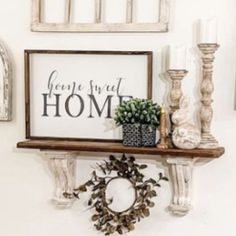 there is a sign that says home next to some candles and other items on the shelf