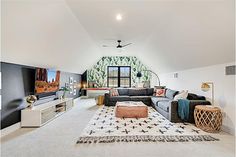 a large living room with white carpet and black couches