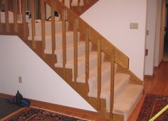 the stairs are made of wood and have white carpet