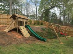 a wooden play set with a green slide