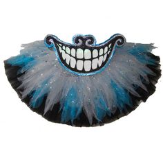 a blue and black mask with white teeth on it's face, decorated with sequins