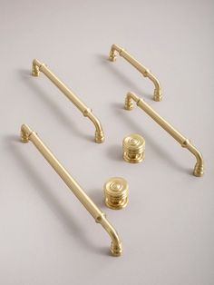 four golden handles and two knobs on a white surface