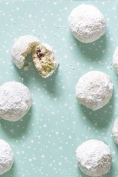 several snowball cookies are on a blue surface