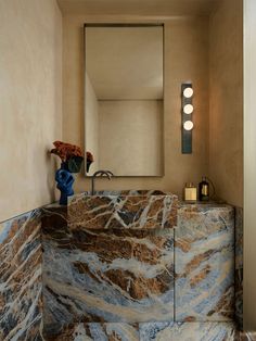 a bathroom with marble counter top and mirror