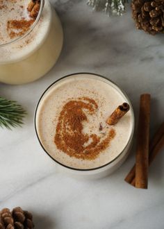 two mugs filled with cinnamon and topped with an image of a man on the side