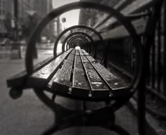 a wooden bench sitting next to a metal fence