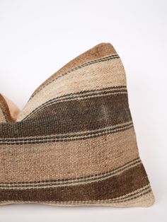 a brown and black striped pillow sitting on top of a white table