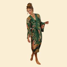 With a luxurious crepe de chine feel for Winter, this Folk Art Kimono is elegant with a gloriously detailed print! The perfect piece for draping over any outfit to add style and sophistication - you will be sure to turn heads wherever you go! Equally suited to wrap around your sleepwear - you will never want to take it off! One size About sizing: dependent on how you would wish to wear the kimono impacts how the fit will be! Some of us wear them open with the belt tied behind, some closed and ti Fitted Floral Print Kimono, Elegant Floral Print Wrap Robe, Fitted Silk Kimono With Floral Print, Fitted Long Printed Kimono, Elegant Wrap Kimono With Floral Print, Elegant Long Sleeve Printed Kimono, Elegant Long Multicolor Kimono, Elegant Green Silk Robe, Fitted Multicolor Silk Kimono