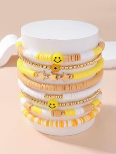 a stack of yellow and white bracelets with smiley faces on them sitting on a table