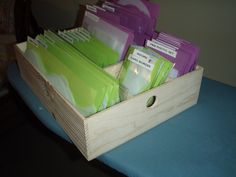 a wooden box filled with files and folders on top of a blue table cloth