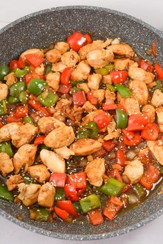 a pan filled with chicken and peppers covered in sauce