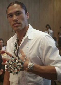 a man standing in front of a group of people holding something up with his hand