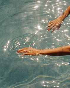 a woman swimming in the water with her arm outstretched out to catch something on it