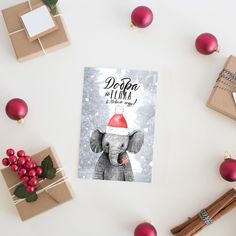 a christmas card with an elephant wearing a santa hat on top of it next to presents