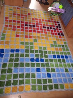 a crocheted blanket is laying on the floor next to a child's toy