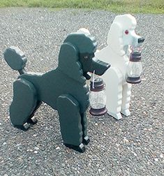 two plastic poodles are sitting on the gravel