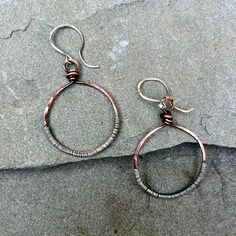 These lovely copper circle earrings have been textirized and patina'ed and the wrapped in sterling silver wire for a unique, artisan look to them.  They are hung on handmade, artisan sterling silver earwires and measure about 2 inches long. Copper And Silver Jewelry, Nickel-free Copper Hoop Earrings, Adjustable Soldered Hoop Earrings For Gifts, Artisan Copper Hoop Earrings Nickel Free, Artisan Nickel Free Copper Hoop Earrings, Artisan Electroformed Hoop Earrings, Copper Wire Wrapped Round Hoop Earrings, Wire Wrapped Copper Hoop Earrings, Unique Copper Wire Wrapped Hoop Earrings