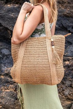 Get ready to carry your beach essentials in style with the Izola Carry All Tassel Tote. This tote features a beautifully woven straw design, giving off boho vibes and adding to your summer vibes. Perfect for more than just beach trips, this tote is a versatile addition to your wardrobe. Woven Straw Exterior Wooden Bead/Straw Tassel AccentLined Interior: 30% Cotton/70% PolyesterMeasurements: 15.75"x17"Handle Drop: 10"Zipper Top ClosureInterior Open Sidewall Pocket Eco-friendly Handwoven Straw Bag For Vacation, Eco-friendly Woven Straw Beach Bag, Eco-friendly Crossbody Straw Bag For Beach, Sand-colored Woven Straw Bag For Beach, Eco-friendly Straw Shoulder Bag For Beach, Straw Design, Global Village, Beach Trips, Straw Tote