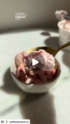 a bowl filled with ice cream sitting on top of a white table next to another bowl