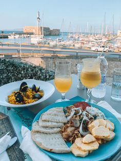 a blue plate topped with food next to a glass of orange juice and two plates filled with food