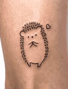 a small hedgehog tattoo on the back of a woman's stomach, with a heart